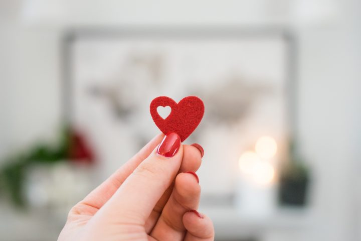 hand holding a small paper heart