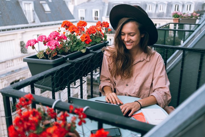 young woman smiling working on a balcony